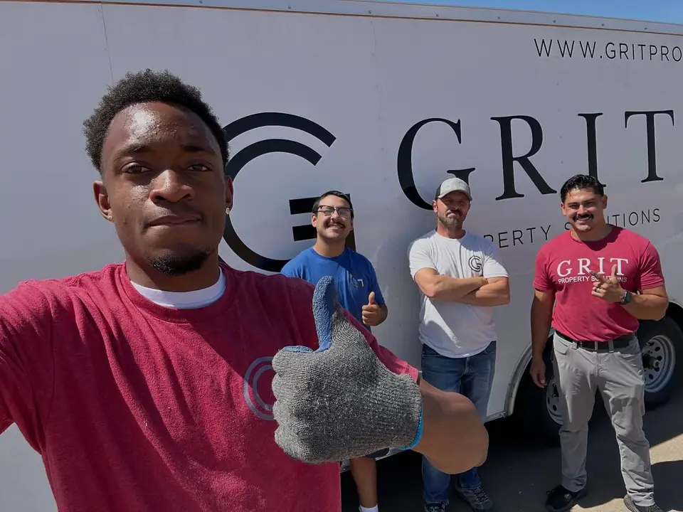 The GRIT crew smiling in front of a GRIT Property Solutions truck