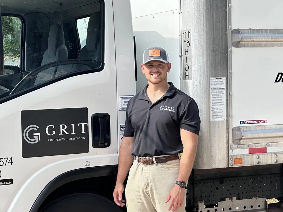 GRIT mover standing beside a GRIT Property Solutions box truck