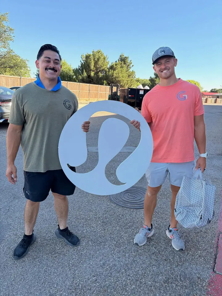 GRIT movers holding a Lululemon sign after relocating the Lubbock store