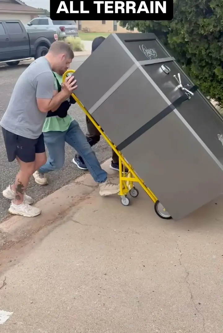 GRIT movers moving a 1,000 lb safe across a yard