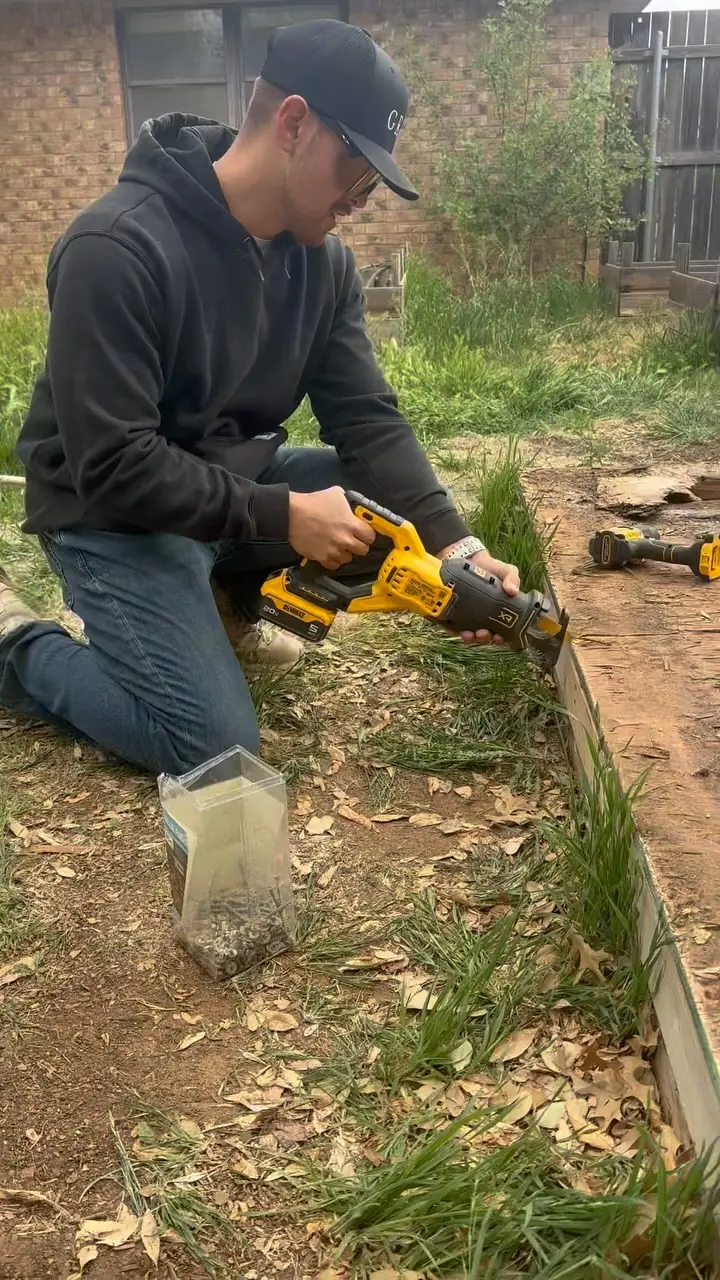 GRIT team member cutting back overgrowth during a yard cleanup